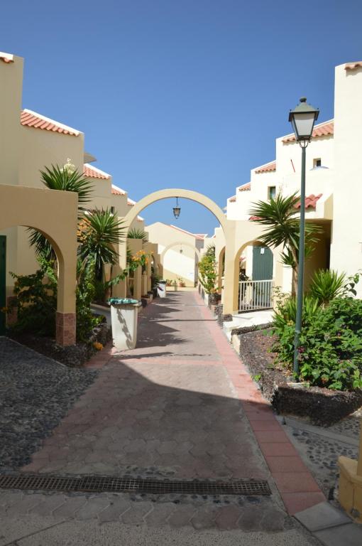 a walkway between houses in a resort with palm trees at Mareverde in Adeje