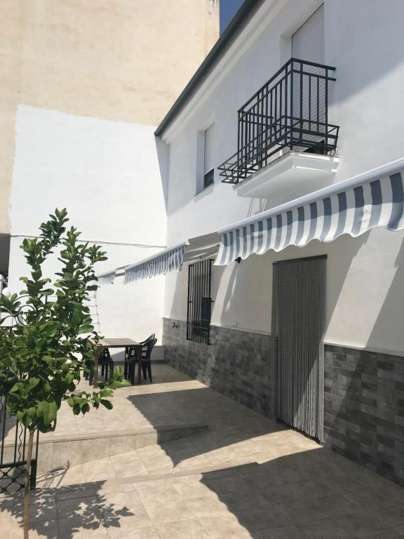 eine Terrasse in einem weißen Gebäude mit einem Balkon in der Unterkunft Casa Macetero en Granada in Granada