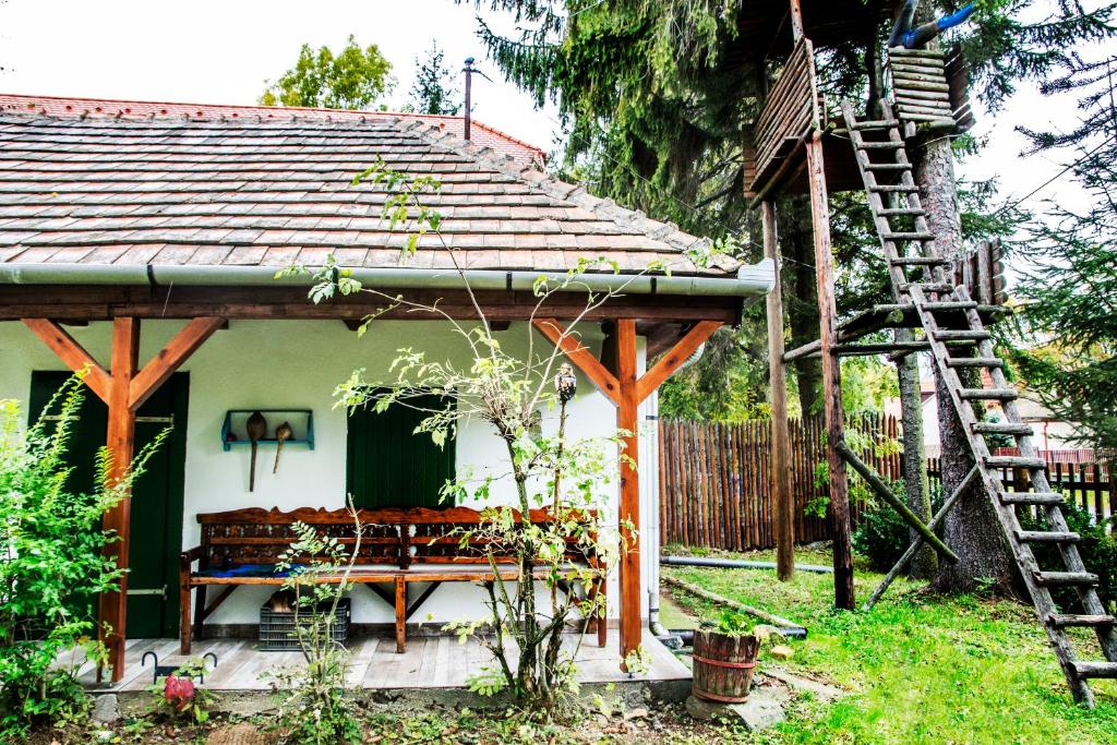 a small house with a bench in the yard at Bagoly lak in Mátraszentimre