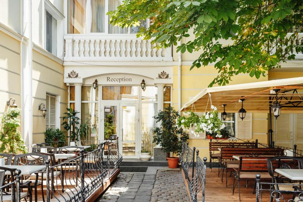 een restaurant met tafels en stoelen voor een gebouw bij Residence Odesskij Dvorik in Odessa