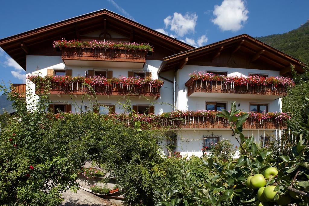 un edificio blanco con flores en las ventanas en Garni & Residence Sonngart, en Lagundo