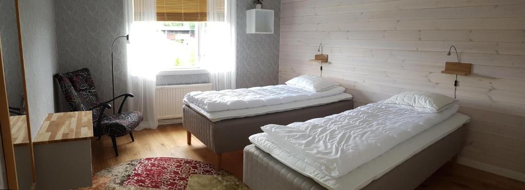 two beds in a room with a window at Mittes Rum in Alingsås