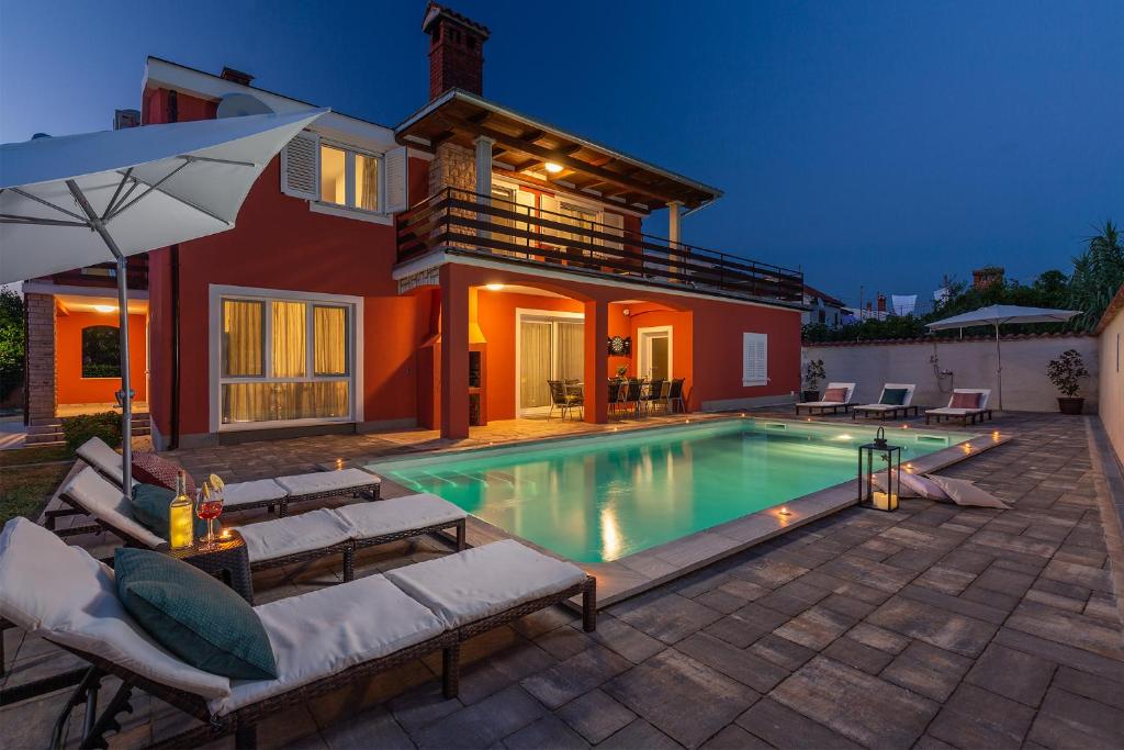 a swimming pool in the backyard of a house at Villa Polion Valbandon in Fažana