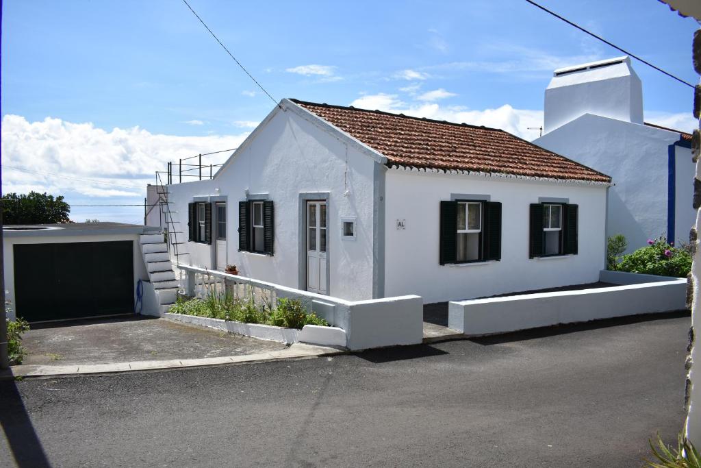 uma pequena casa branca com garagem em Casa da Guida em Lajes das Flores