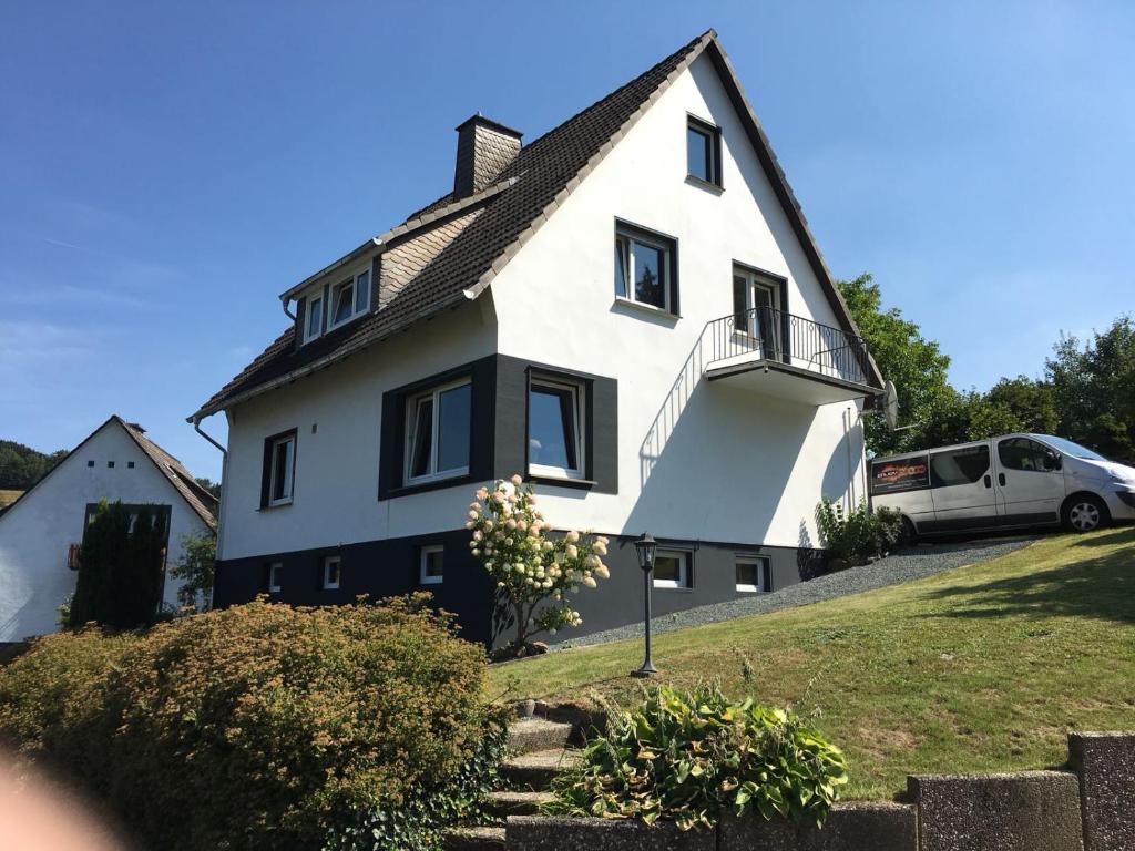 une maison blanche avec un toit noir dans l'établissement Haus am Kreuzberg, à Winterberg