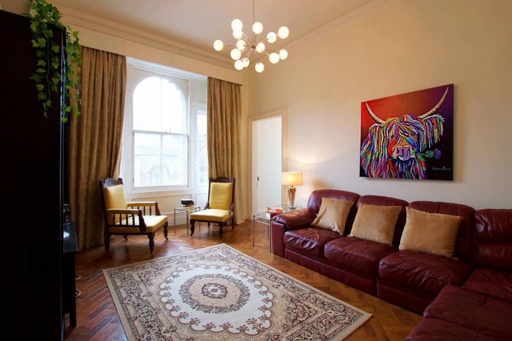 a living room with a couch and a painting of a tiger at ALTIDO Castle Terrace 3 bedroom Apartment - Old Town in Edinburgh