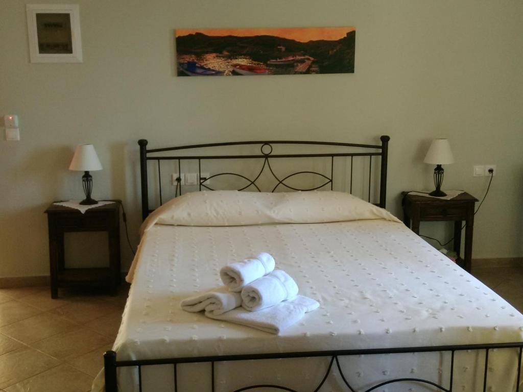 een slaapkamer met een bed met 2 opgerolde handdoeken bij Vilana Studios in Kálamos Kythira