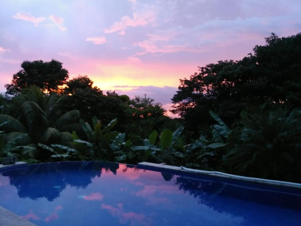 a swimming pool with a sunset in the background at Studio Pilon De Pavones in Pavones