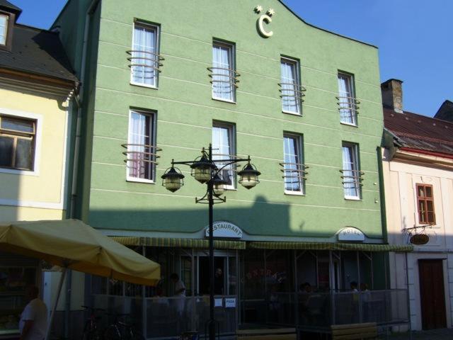 a green building with a street light in front of it at Hotel Centrál in Kremnica