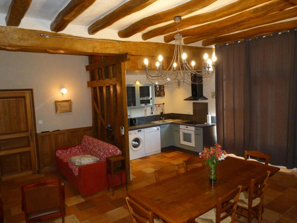 a living room with a dining room table and a kitchen at Le Grand Gite De La Promenade in Montoire-sur-le-Loir