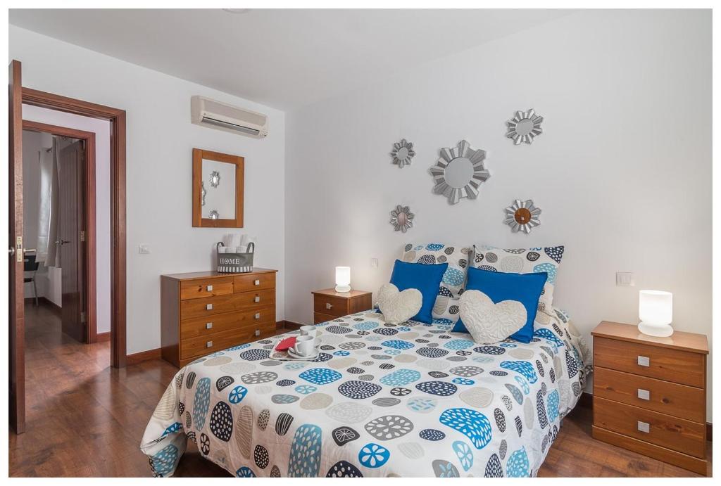a bedroom with a bed with a blue and white comforter at La Casita del Centro in Vega de San Mateo