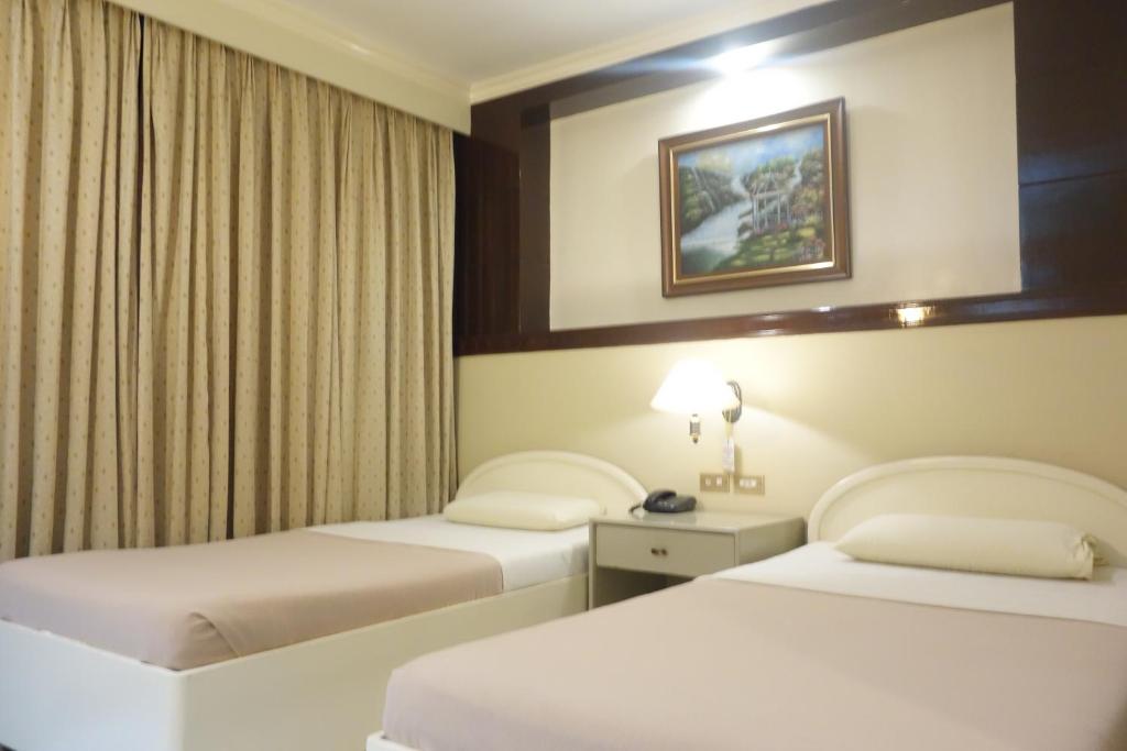 pokój hotelowy z 2 łóżkami i lampą w obiekcie Hotel Canelsa w mieście Tacloban