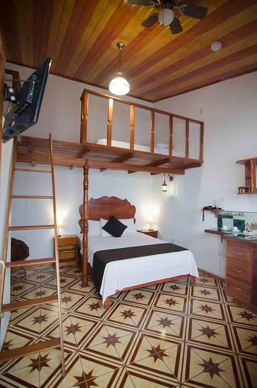 a bedroom with a bunk bed and a tv at Epoca Iquitos in Iquitos