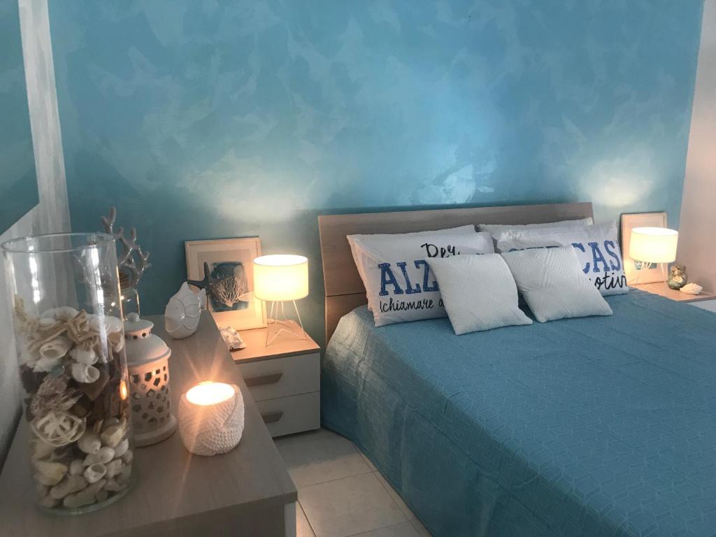 a bedroom with a bed and two tables with lamps at Apulia Home in Zapponeta