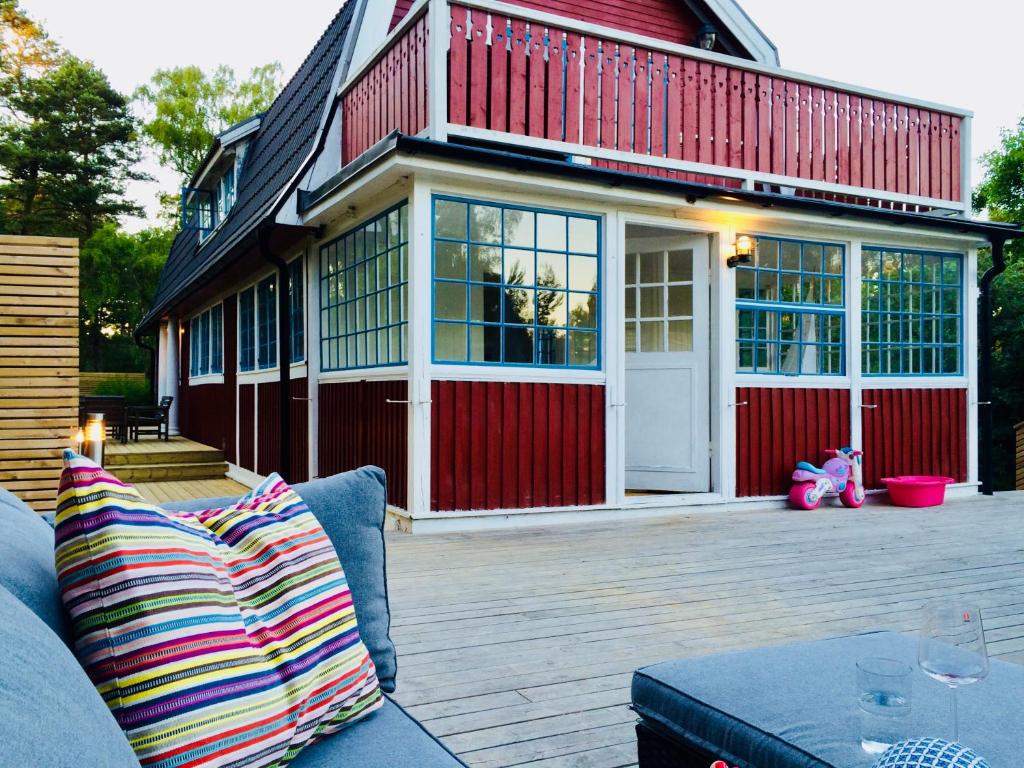 a couch sitting on a patio with a house at Ljunghusen in Höllviken