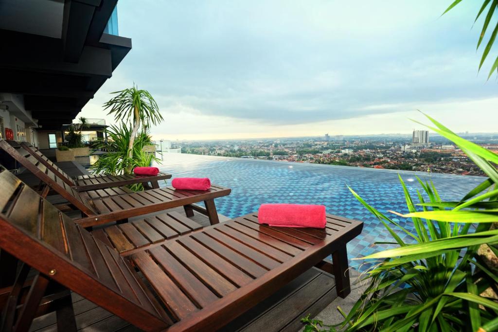 two benches on a balcony with a view of the water at Holiday Villa Johor Bahru City Centre in Johor Bahru