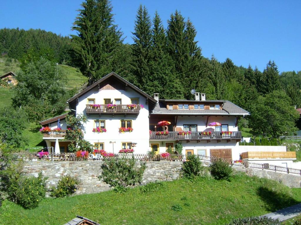 Una gran casa blanca con balcones en una colina en Haus Rupitsch en Winklern