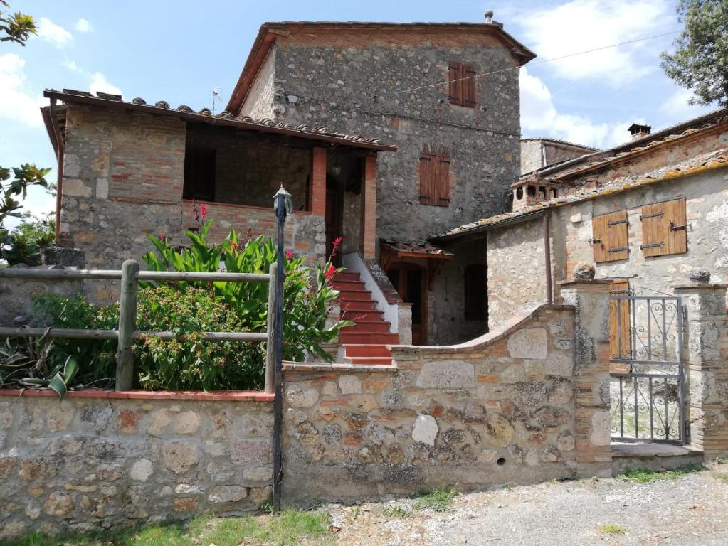 ein altes Steinhaus mit einer Treppe davor in der Unterkunft IL Fienile nella Roccia in Casole dʼElsa