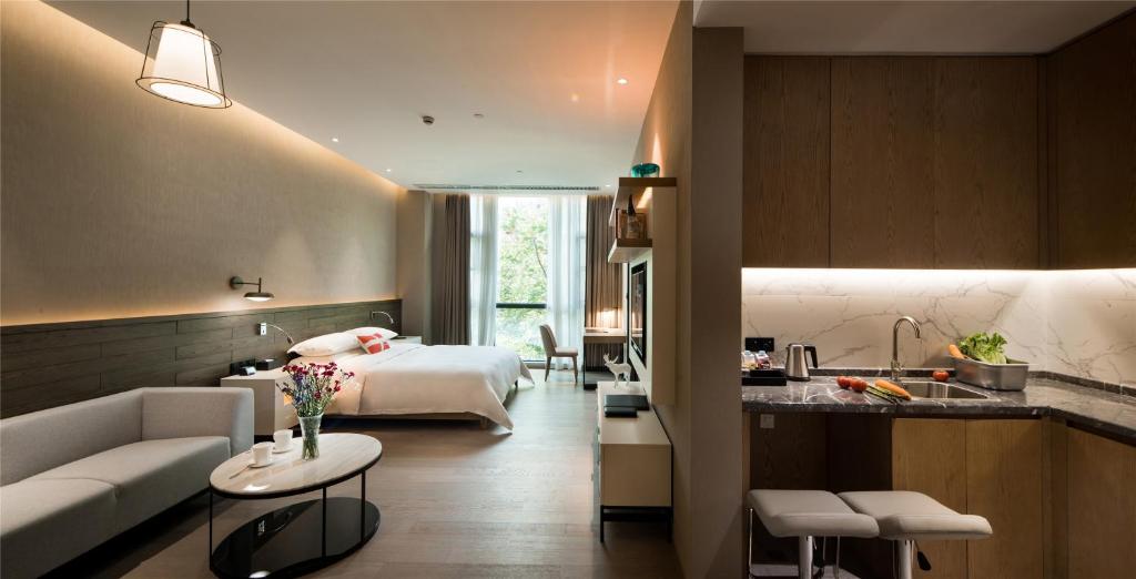 a hotel room with a bed and a kitchen at Swisstouches Guangzhou Hotel Residences in Guangzhou