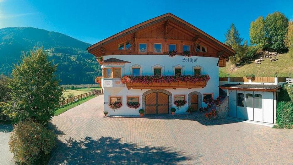 a large white building with a wooden roof at Zollhof in Vipiteno