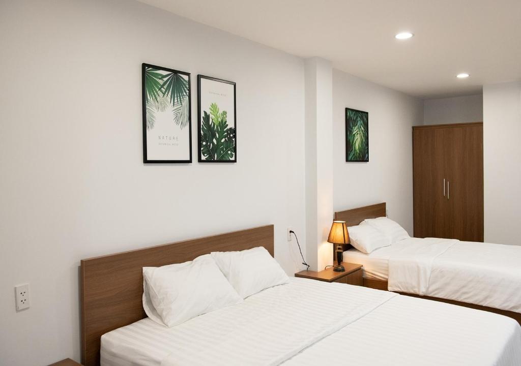2 camas en una habitación de hotel con sábanas blancas en Vic House Hotel en Da Nang