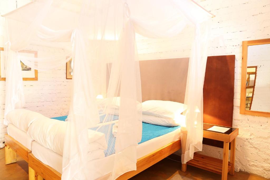 a bedroom with a canopy bed with white drapes at Evening Shade in Omaruru