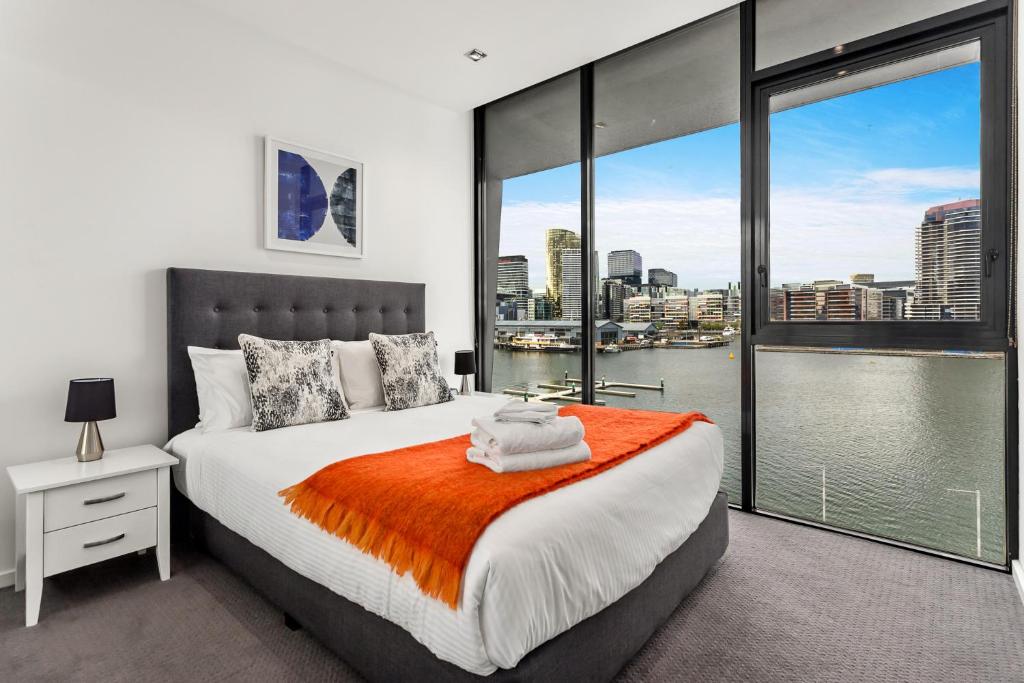 a bedroom with a large bed and a large window at Docklands Private Collection - NEWQUAY in Melbourne