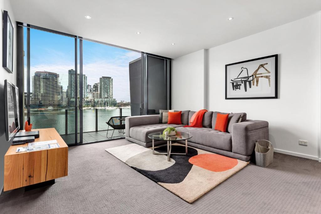 a living room with a couch and a large window at Docklands Private Collection - NEWQUAY in Melbourne