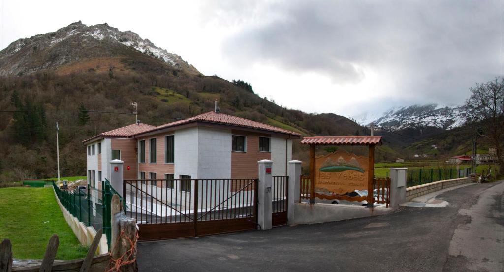 a house with a gate in front of a mountain at Apartamentos Rurales Las Vegas de Cardeo in Las Vegas De Cardeo