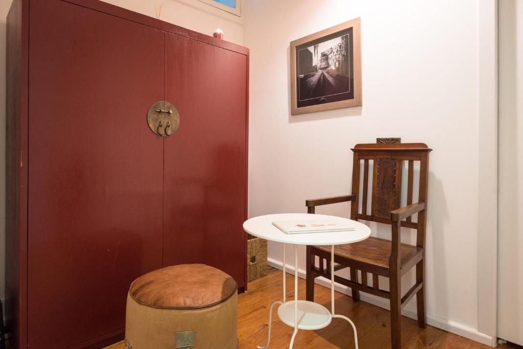 リスボンにあるFeel@home Lisboaのテーブル、ドア、スツール付きの部屋
