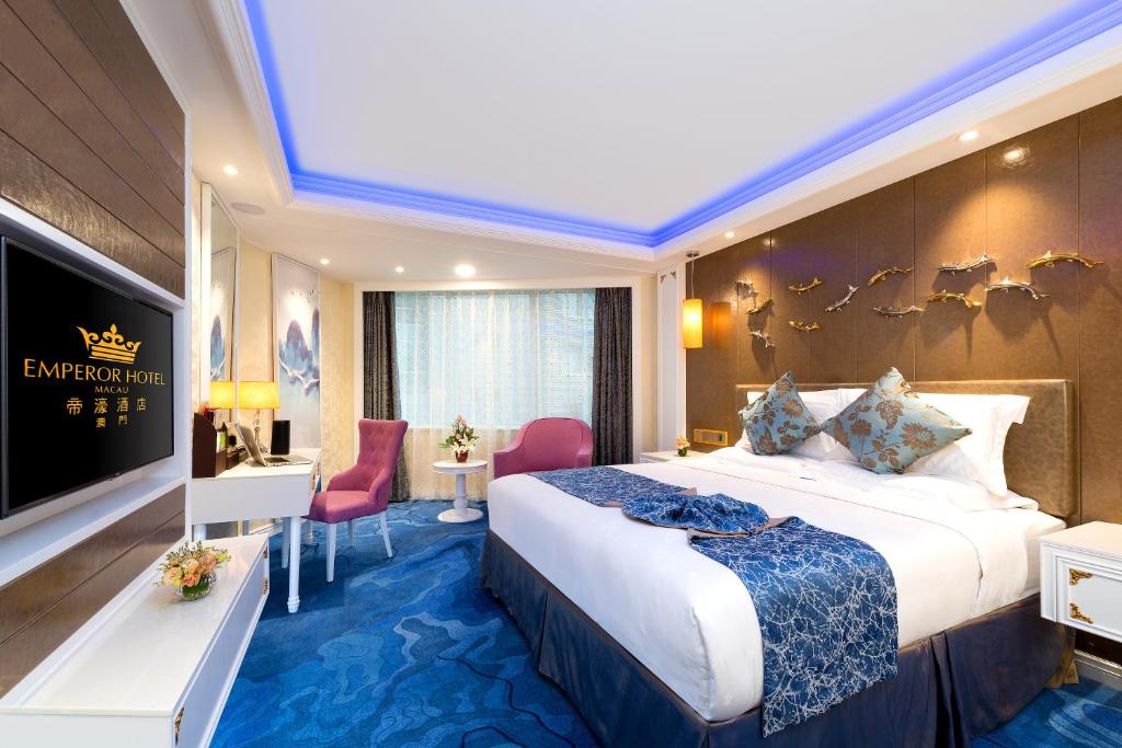 Habitación de hotel con cama grande y TV en Emperor Hotel, en Macau