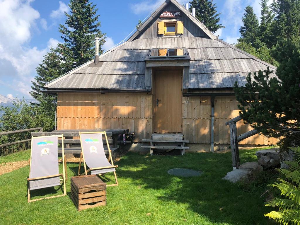 un vecchio fienile con due sedie davanti di Chalet Košutnik Velika planina a Kamniška Bistrica