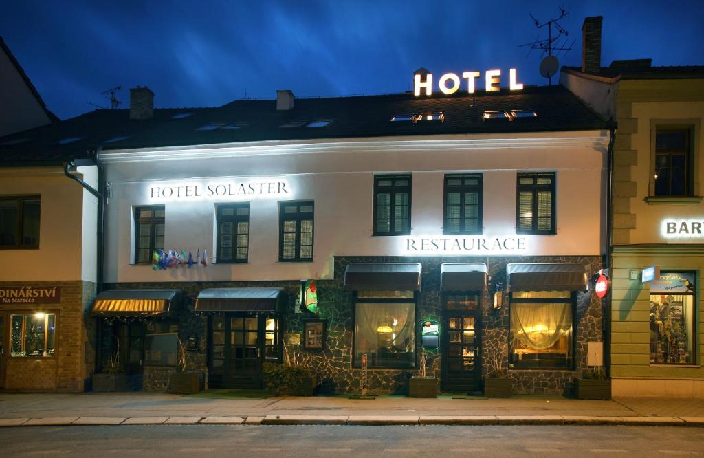 a large building with a neon sign on the side of it at Hotel Solaster Garni in Třebíč