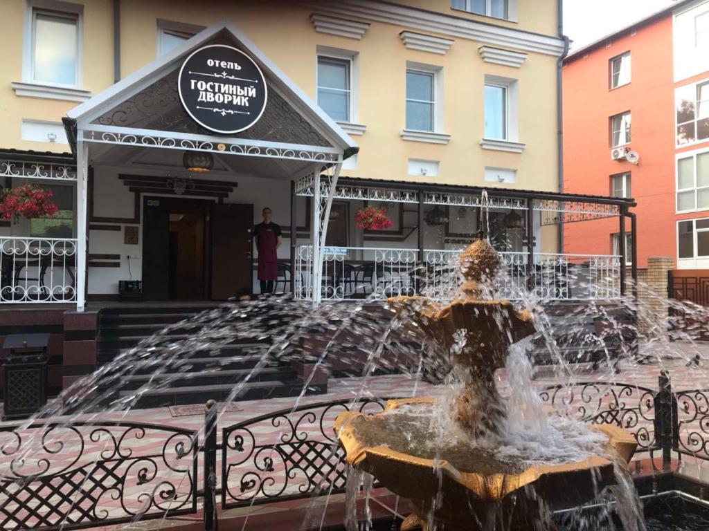 a fountain in front of a building next to a building at Gostiniy Dvorik Guest House in Yaroslavl