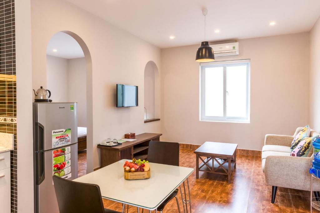 cocina y sala de estar con mesa y nevera en Nghi Son Hotel en Thanh Hóa