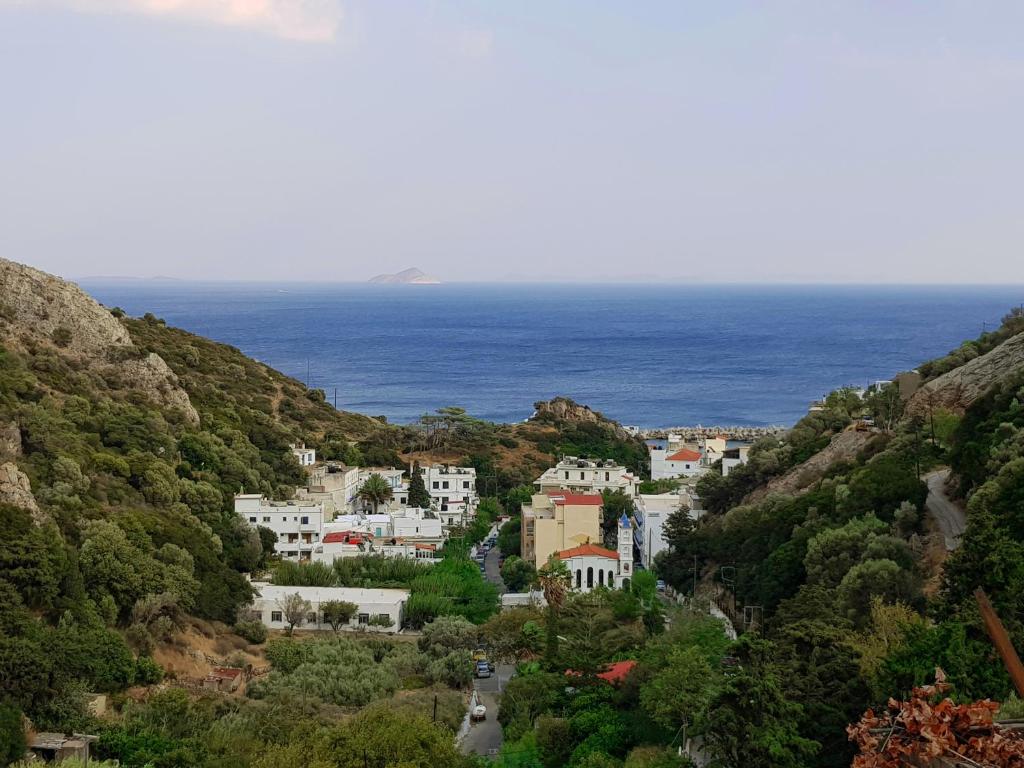 a view of a town on a hill with the ocean at Iasonas Rooms in Agios Kirykos