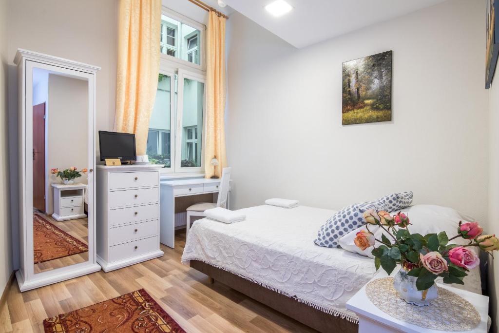 a bedroom with a bed and a desk and a mirror at Pokoje Gościnne Unikat - Self check in in Kraków