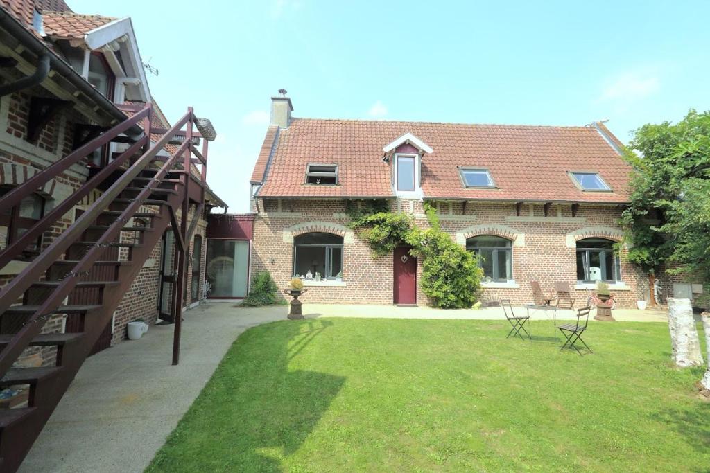 una gran casa de ladrillo con césped delante en La suite d'Arras, en Agny