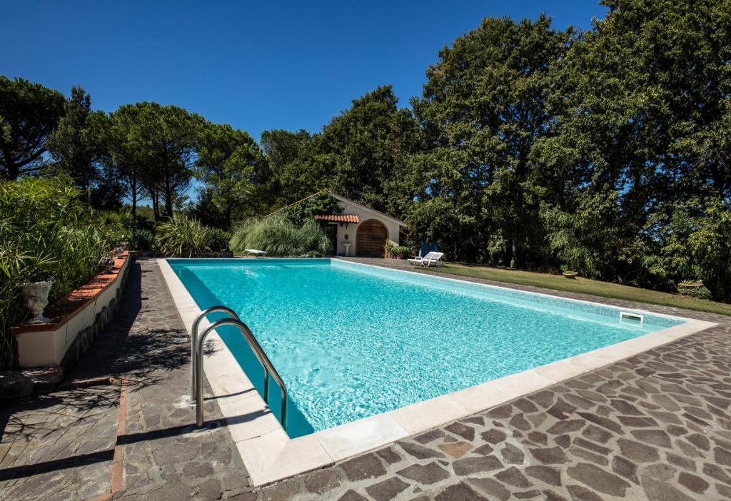 basen z błękitną wodą na dziedzińcu w obiekcie Podere il Giurato w mieście Fauglia