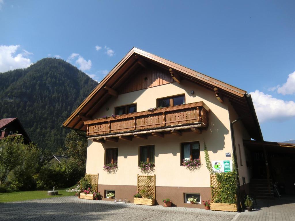 a building with a balcony and mountains in the background at Haus Rye in Obertraun