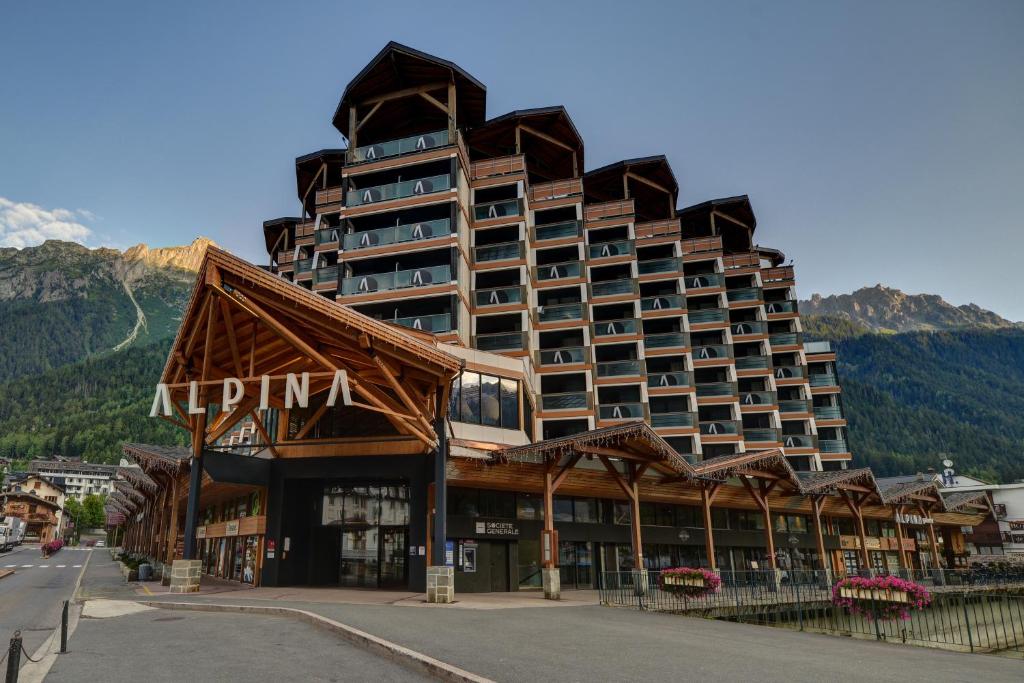 a large hotel building with a building with a mountain at Alpina Eclectic Hotel in Chamonix-Mont-Blanc