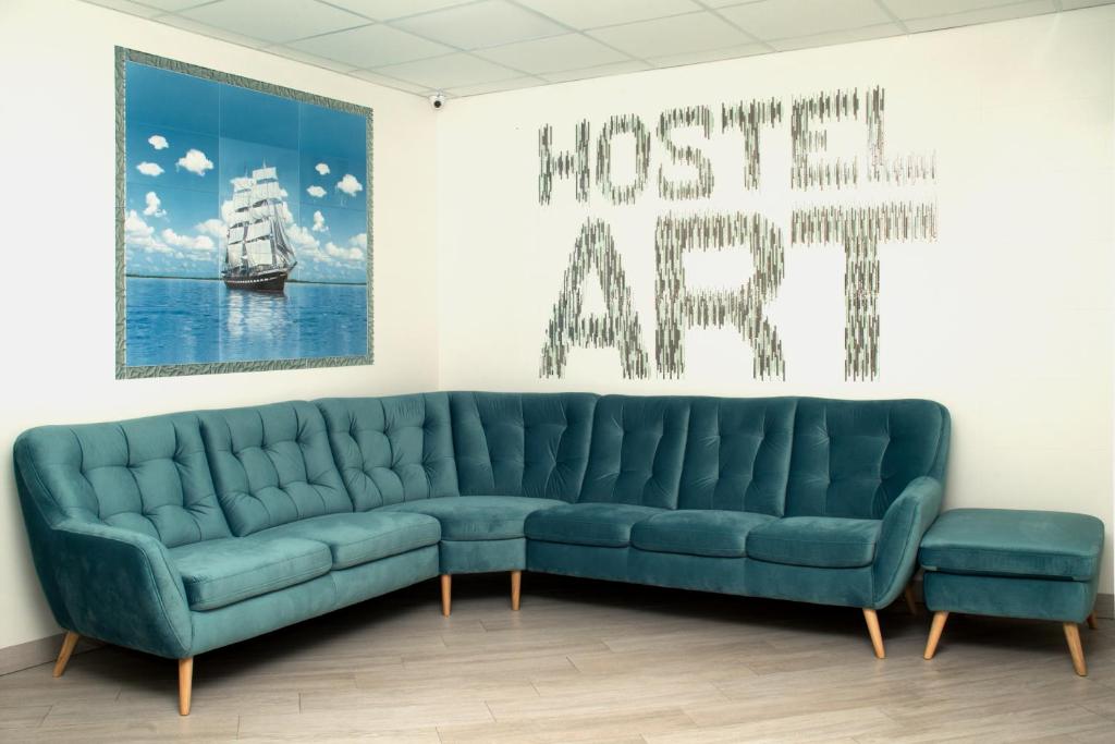 ゼレノグラーツクにあるHostel Artの絵画のある部屋に青いソファが備わります。
