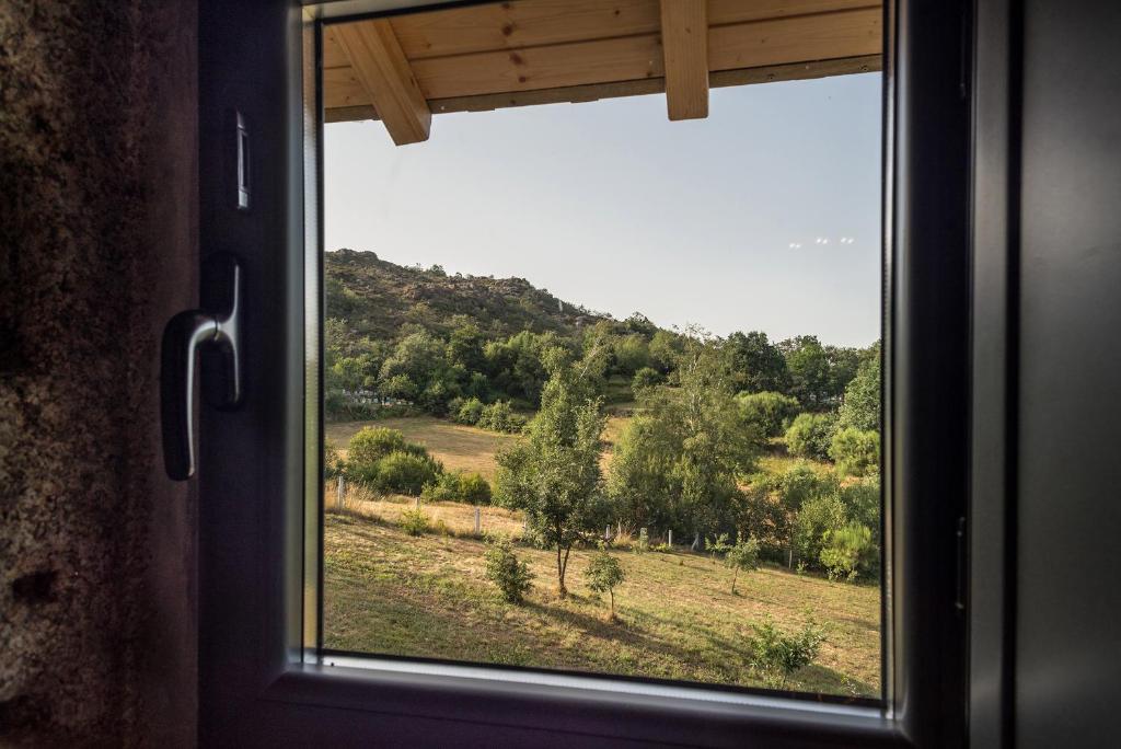 a window in a room with a view of a field at Casa Alagoa in Castro Laboreiro