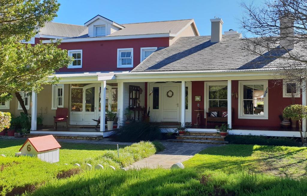 una casa con una casa roja y blanca en African Breeze Guesthouse, en Knysna