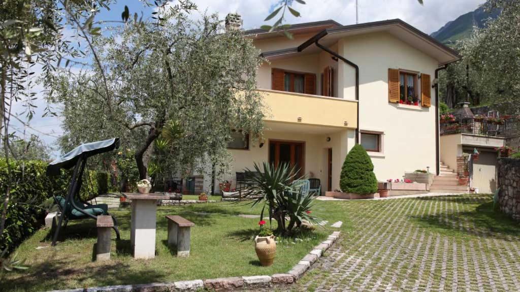 a house with a garden in front of it at Appartamento SOLE in Brenzone sul Garda