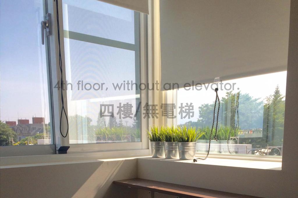 a window with potted plants on a window sill at HomeStay LB in Taitung City