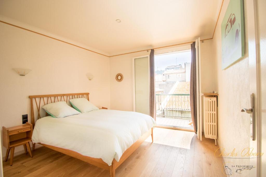 a bedroom with a bed and a large window at Chez Emy in Sète