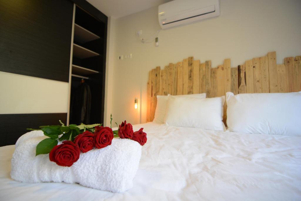 a white bed with red roses on it at Luna BaNeguev in Yeroẖam