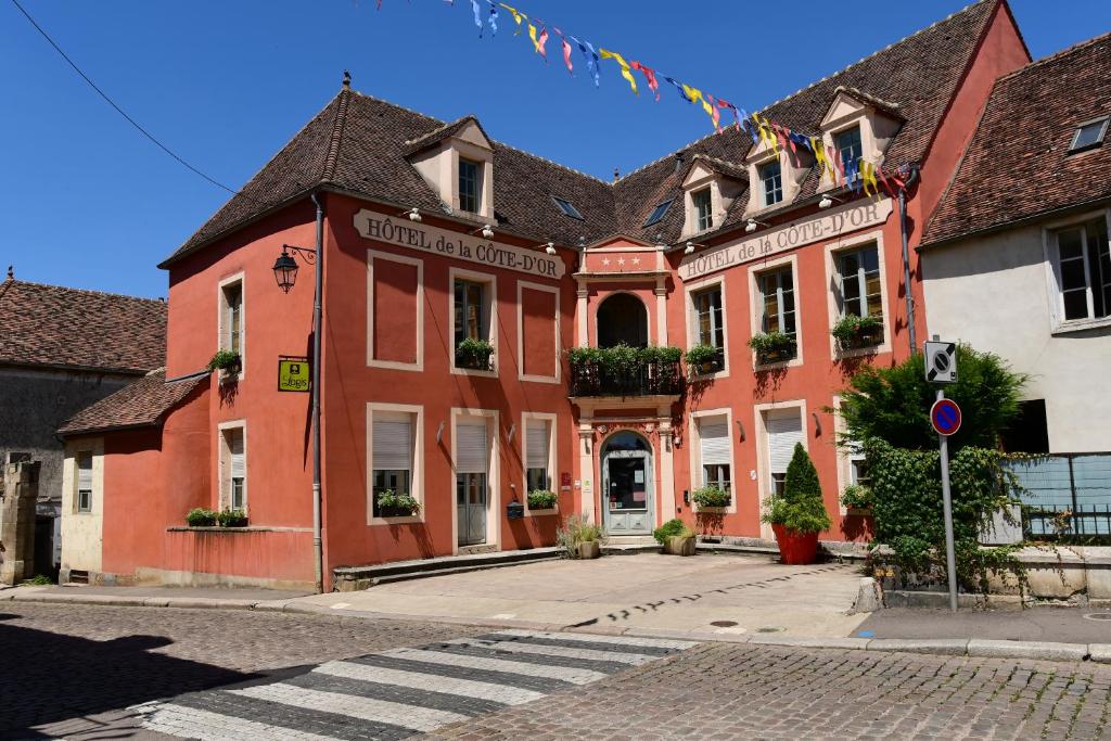 - un vieux bâtiment dans une ville avec une promenade dans l'établissement Hotel Relais De La Cote D'or, à Semur-en-Auxois