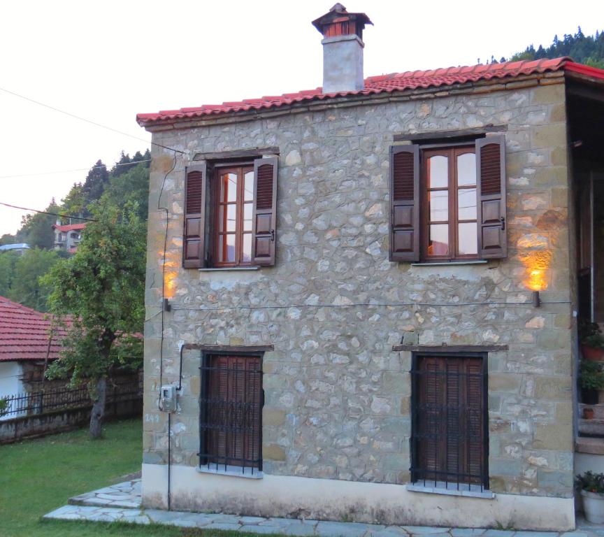 una casa de piedra con cuatro ventanas en el lateral. en Traditional Stone House en Elati Trikalon